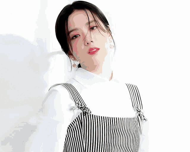 a woman wearing a black and white striped dress and a white shirt