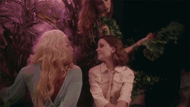 a woman with blonde hair is sitting next to another woman with red hair