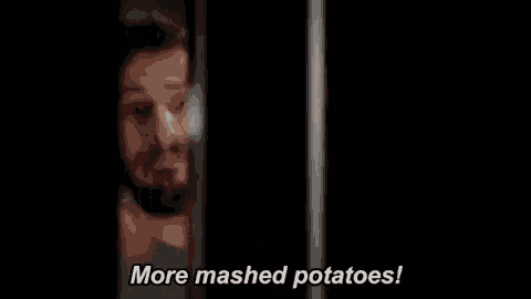 a man with a beard is looking out of a window and says `` more mashed potatoes '' .
