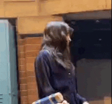 a woman in a hooded jacket is walking down the street .