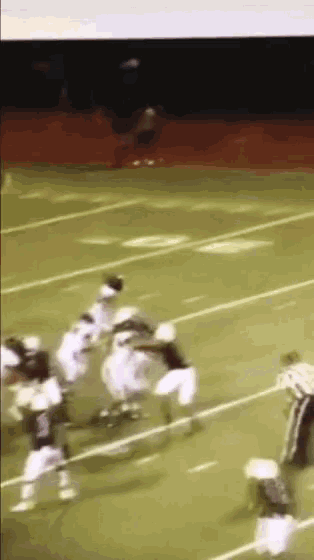 a group of football players on a field with a referee in the background