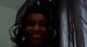a close up of a person 's face in front of a curtain