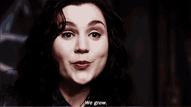 a close up of a woman 's face with the words " we grow " below her