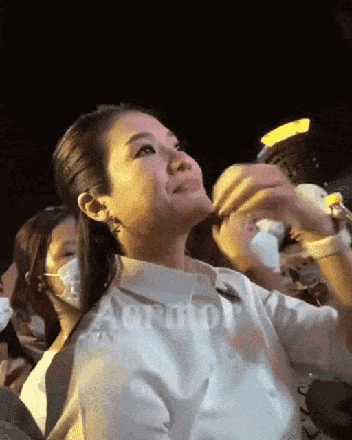 a woman wearing a white shirt with the word agro on the sleeve