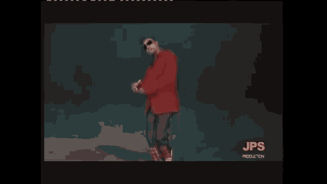 a man in a red jacket and plaid pants is dancing on stage .