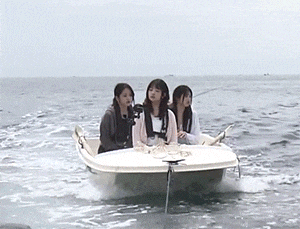 three young women are riding a small boat in the ocean