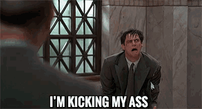 a man in a suit says i 'm kicking my ass in front of a window