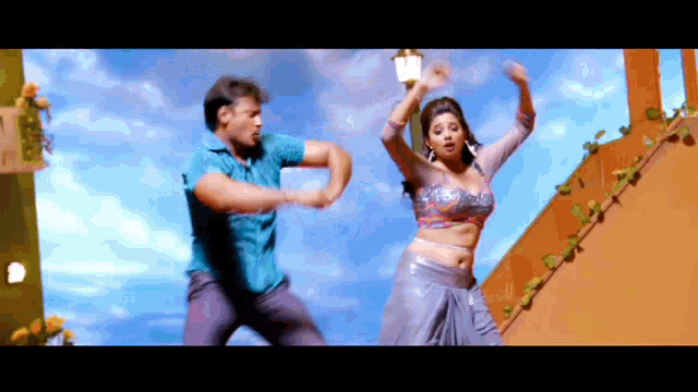 a man and a woman are dancing on a balcony