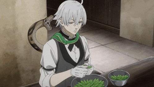 a man with a snake around his neck is preparing food