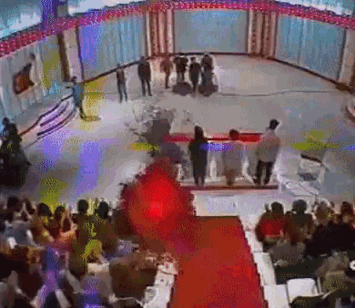 a group of people are standing on a stage in front of a red carpet