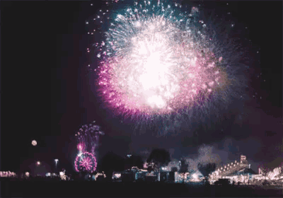 fireworks are displayed in the night sky with arabic writing on the bottom