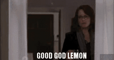 a woman is standing in a doorway holding a glass of wine and talking about good god lemon .