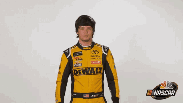 a man wearing a yellow and black racing suit with the word dewalt on it .