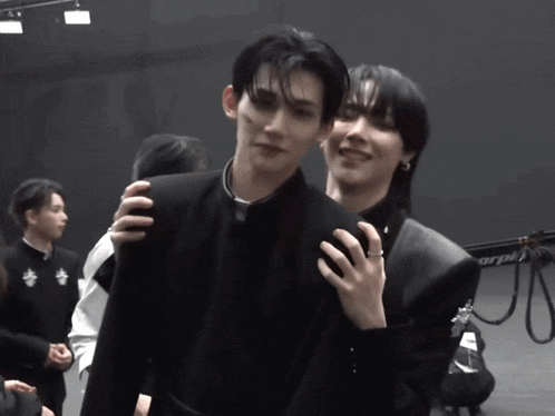 a man with a ring on his finger stands next to another man