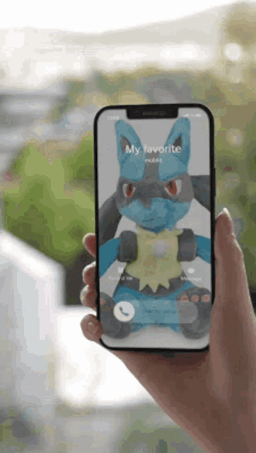 a person is holding a phone with a stuffed animal on the screen that says my favorite mobile