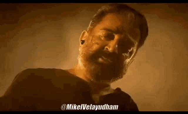 a man with a beard and piercings in his ears is standing in front of a fire .