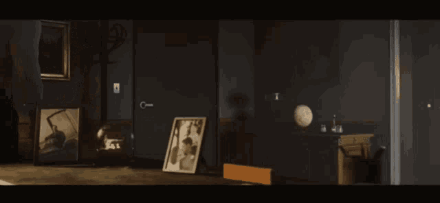 a man is standing in a dark room with a picture on the table