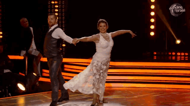 a man and a woman are dancing on a stage with the words dancing brasil behind them