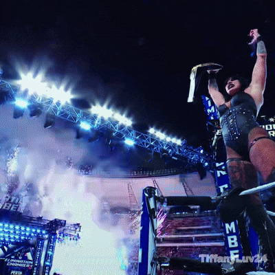 a woman is holding a championship belt in the air in front of a stadium that says tiffany luv24