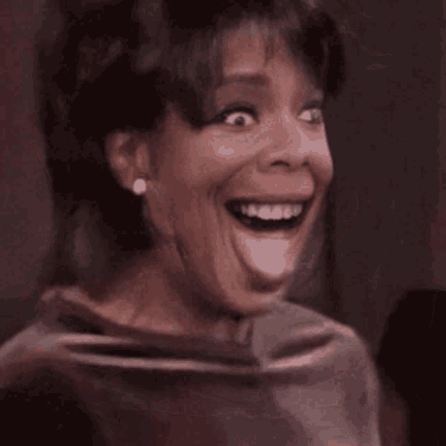 a close up of a woman 's face with a huge smile on it .