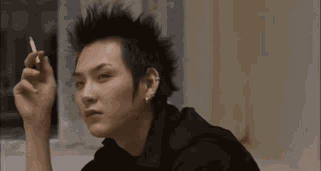 a man with a mohawk smoking a cigarette