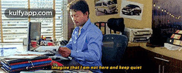 a man sits at a desk in front of a computer with the words imagine that i am not here and keep quiet on the bottom