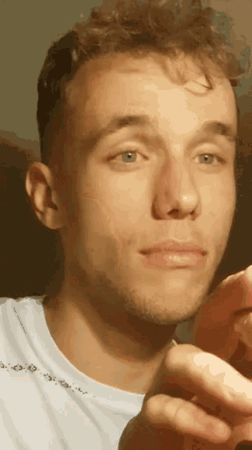 a close up of a man 's face with a white shirt that says ' no pain '
