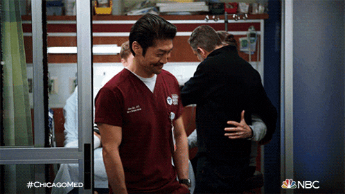 two men are hugging in a hospital room with #chicagomed written on the bottom right