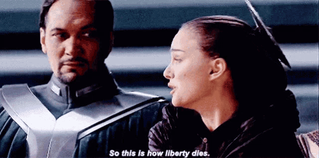 a man and a woman are standing next to each other and the woman is saying `` so this is how liberty dies '' .