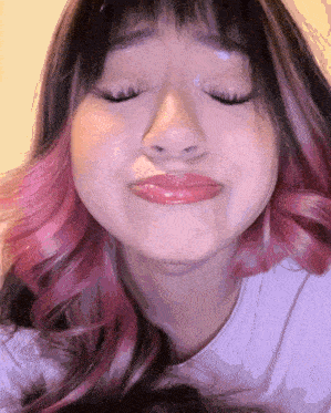 a woman with pink hair is making a funny face