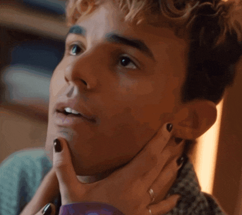 a close up of a man 's face with a woman holding his neck