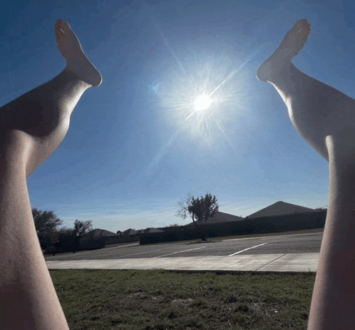 a person 's legs are stretched out towards the sun