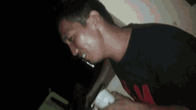 a man in a black shirt is holding a white cup in his hands