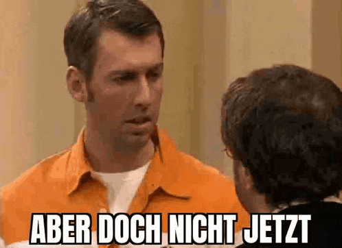 a man in an orange shirt is talking to another man with the words aber doch nicht jetzt above him .