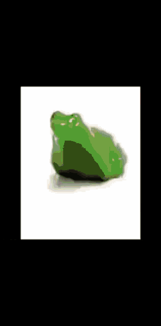 a green frog is sitting on a white surface in the snow