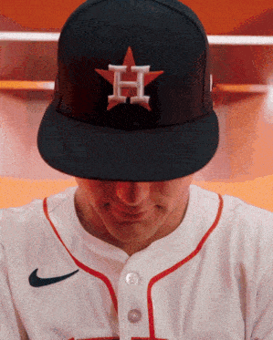 a baseball player is wearing a black hat with the letter h embroidered on it