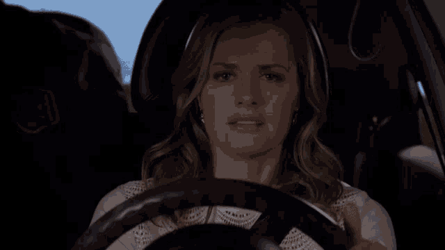 a woman is driving a car with her eyes closed