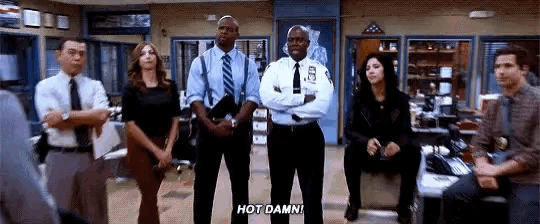 a group of police officers are standing in a room with their arms crossed and one of them is saying `` hot damn ''