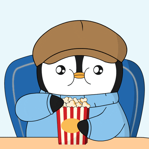 a penguin is sitting at a table eating popcorn
