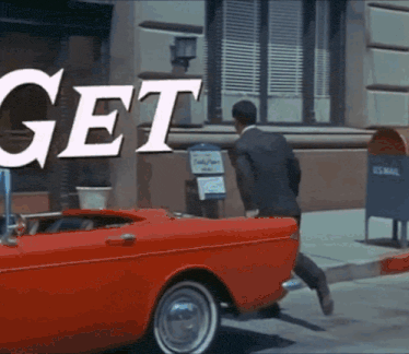 a man in a suit is running towards a red car that says get on the side