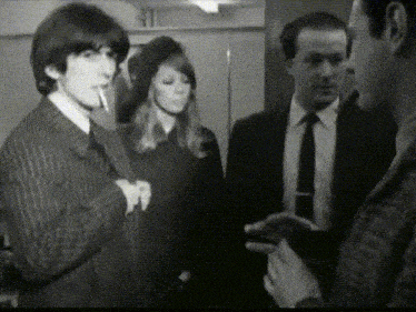 a man is smoking a cigarette while standing next to a woman