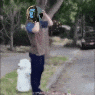 a person standing next to a fire hydrant with a blue face painted on it