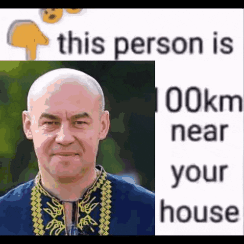 a bald man in a blue shirt is next to a white sign that says this person is 100km near your house .