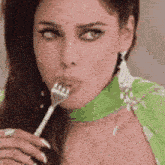 a woman is holding a fork to her mouth .