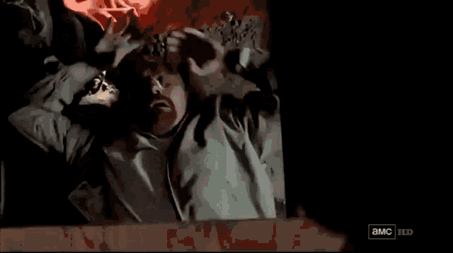 a man is laying in a box with blood coming out of his head and a sign that says a.m.c. hd
