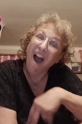a woman wearing glasses and a black shirt is making a face