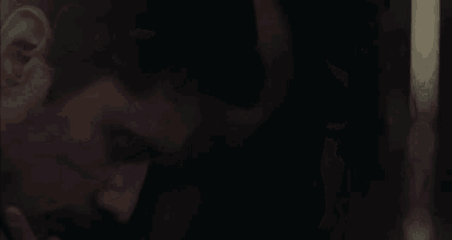 a man and woman are looking at each other in the dark .