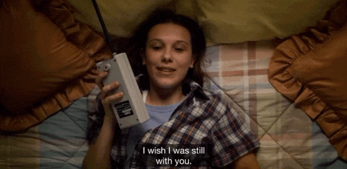 a woman laying on a bed talking on a cell phone