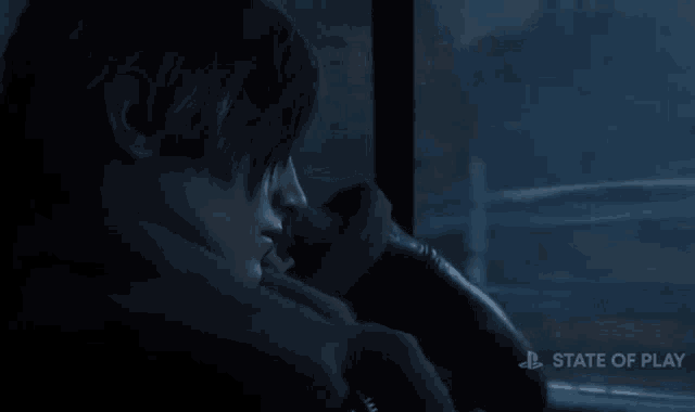 a man sitting in a dark room with a state of play logo on the bottom