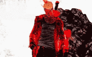a man in a red jacket is standing in front of a pile of rocks .